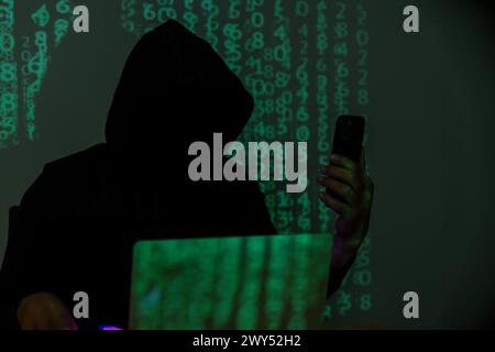 Hacker using cell phone for hacking Stock Photo