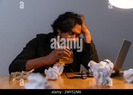 The young businessman is stressed and drinking alcohol Stock Photo