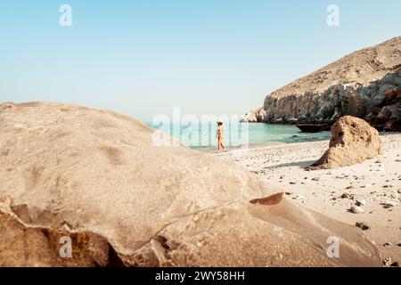 Aerial view isolated tourist woman in bikini walk on white sand beach alone in persian gulf Mirellas island. Musandam.Oman Stock Photo
