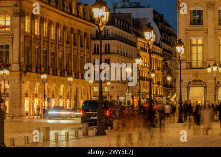 Paris, France - February 17, 2024 : View of the illuminated street lamps at the busy Place Vendôme with its luxurious shops and hotels in Paris France Stock Photo