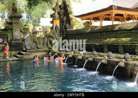 Tampak Siring, Tampaksiring, Bali in Indonesia - January 31 2024: people take a bath in the Tirta Empul temple (Holy Spring Water Temple) Stock Photo