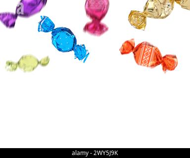 Candies in bright wrappers falling on white background Stock Photo