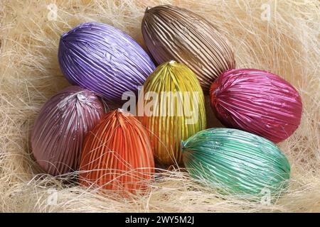 Colorful Easter chocolate eggs in straw nest. Stock Photo
