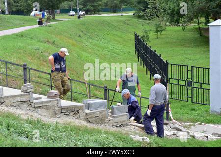 Builders in a city park are repairing a staircase. Stock Photo