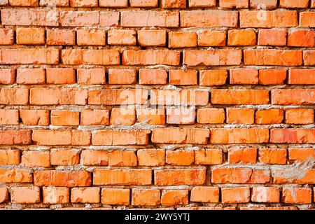 grungy pattern of an orange brick wall. not finished or abandoned architecture development concept. dirty and uneven texture Stock Photo