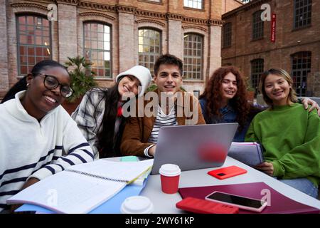 Portrait of a group of students looking at camera outside at university campus studying together. Stock Photo