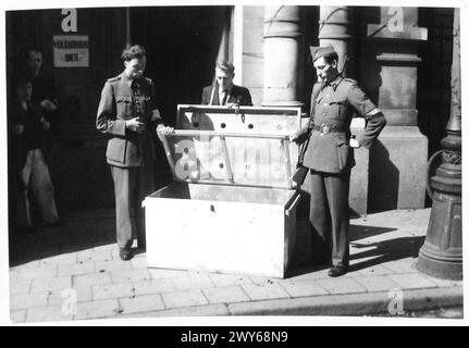 GERMAN ATROCITIES AND TORTURE AGAINST THE BELGIAN PEOPLE. - Men of the Brigade Blanche examining the box. , British Army, 21st Army Group Stock Photo