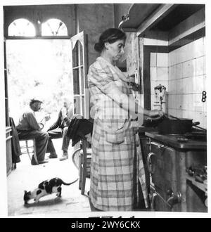 A FRENCH FAMILY RETURN TO THEIR SHELL TORN VILLAGE - Now that the kitchen has been cleaned out Madame Le Du starts to prepare a meal for the family. , British Army, 21st Army Group Stock Photo