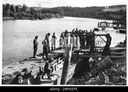 BUILDING A CLASS 40 FLOATING BAILEY BRIDGE OVER THE SEINE - Moving pontoon section into position along the river bank, prior to assembling the bridge, , British Army, 21st Army Group Stock Photo