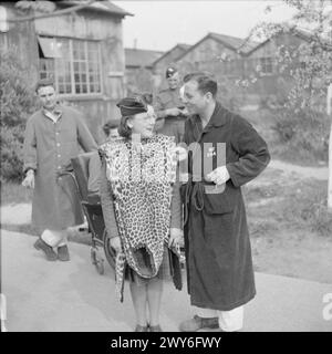 ATS BAND VISITS AMERICAN HOSPITALS: ENTERTAINMENT FOR WOUNDED SOLDIERS, WILTSHIRE, ENGLAND, UK, APRIL 1945 - A drummer of the Auxiliary Territorial Service, wearing a leopard skin tabard over her uniform, chats to James Padget, a wounded American soldier, at a General Hospital in Wiltshire. According to the original caption, Padget is from Columbia, Carolina. Several other patients can be seen in the background. , British Army, Auxiliary Territorial Service Stock Photo