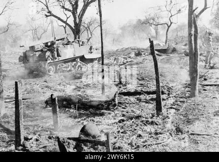 THE BRITISH ARMY IN BURMA 1945 - A Bren gun carrier moves through the devastated outskirts of Ywathitgyi village, February 1945. , Stock Photo