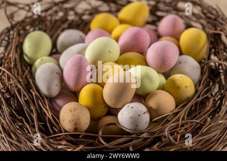 Close-up of colourful sugar-coated chocolate mini eggs arranged in a faux bird's nest. Stock Photo