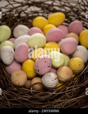 Close-up of colourful sugar-coated chocolate mini eggs arranged in a faux bird's nest. Stock Photo
