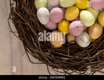 Close-up of colourful sugar coated chocolate mini eggs arranged in a faux bird's nest. Stock Photo