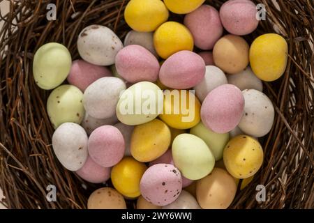 Close-up of colourful sugar coated chocolate mini eggs arranged in a faux bird's nest. Stock Photo