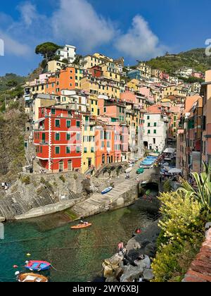 Riomaggiore, Italy - October 8, 2023: landscape view of typical ligurian village of cinque terre, Riomaggiore with many tourists along the bay Stock Photo