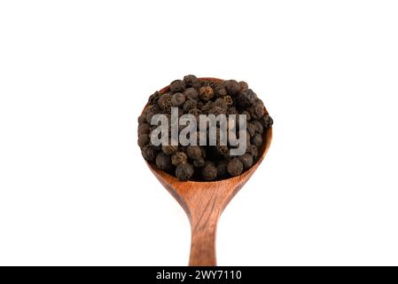 Close-up of wooden spoon with black pepper peas over white background. Food seasonings. Stock Photo