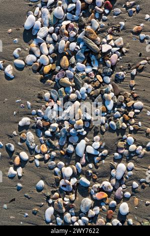 Colourful pebbles on sand at a beach of Greece Stock Photo
