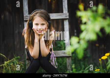 A cute girl wearing headphones in the countryside. Stock Photo