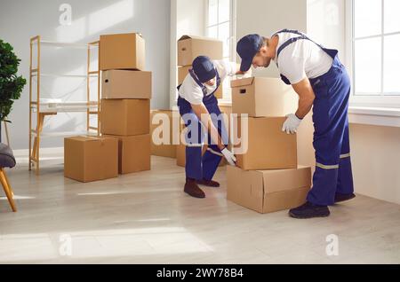 Workers from home removals company removing packed up boxes from house or apartment Stock Photo