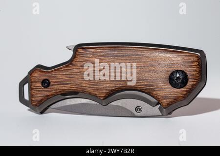 Stylish pocket knife with silver blade and wooden handle for outdoor and daily use. Elegant design against a clean white background. Stock Photo