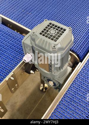 Electric motors in the stainless steel conveyor system with polyurethane, modular belt. Transport systems in industrial factories. Stock Photo