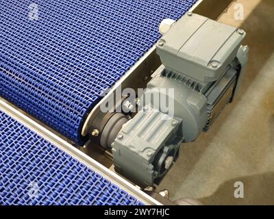 Electric motors in the stainless steel conveyor system with polyurethane, modular belt. Transport systems in industrial factories. Stock Photo