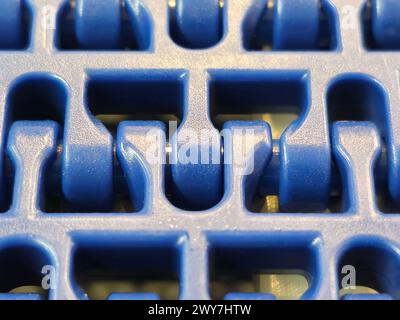 A close-up of a blue polyurethane belt in modular industrial conveyor system. Transport systems in industrial factories. Stock Photo