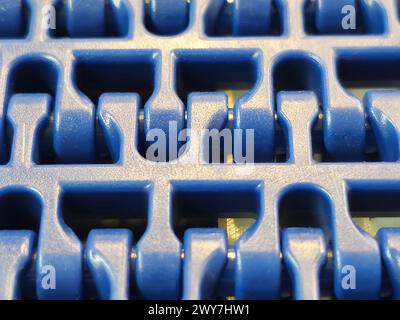 A close-up of a blue polyurethane belt in modular industrial conveyor system. Transport systems in industrial factories. Stock Photo