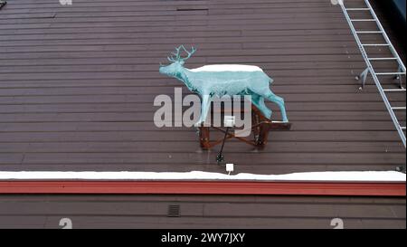 Kiruna, Sweden, February 23, 2020. Art, the statue of a reindeer on the wall of a wooden building in the snowy center of Kiruna in northern Sweden dur Stock Photo