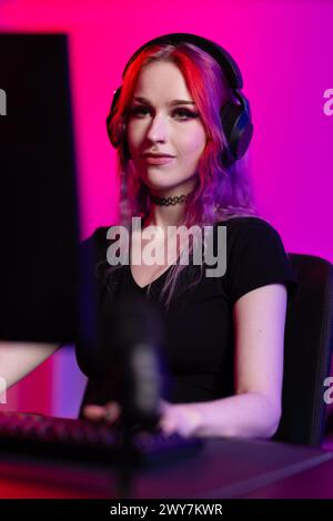 Focused Female Gamer Playing in Neon-Lit Room Stock Photo