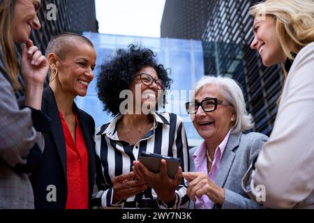 Professional business women talking about work matters using and looking tablet pc in their hands Stock Photo