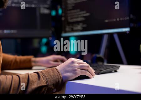 Freelancing cybersecurity admin using computer to look for company security vulnerabilities. IT engineer typing on keyboard, installing fortified code on PC to prevent cyber attacks, close up Stock Photo