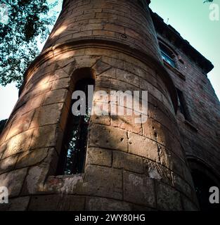 A stone tower with surrounding trees and a small windowh Stock Photo