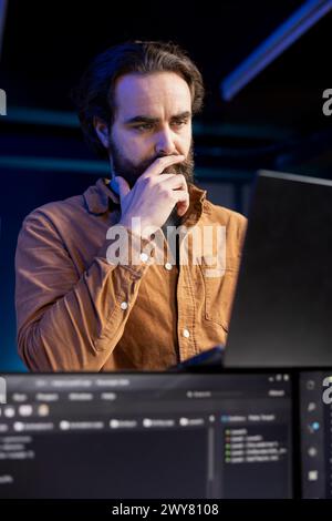 Reflective programmer debating how to design and develop software applications. Puzzled IT specialist trying to come up with solutions while implementing and maintaining company systems Stock Photo