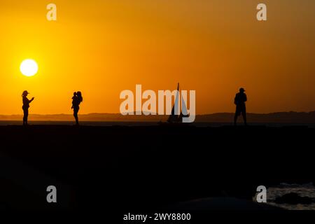 Salvador, Bahia, Brazil - March 15, 2019: People, in silhouette, are seen on the Porto da Barra pier enjoying the sunset in the city of Salvador, Bahi Stock Photo