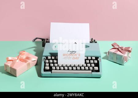 Vintage typewriter, gift boxes and tulips for Women's Day on turquoise table against pink background Stock Photo