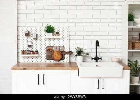 Stylish light kitchen with pegboard and kitchenware Stock Photo - Alamy
