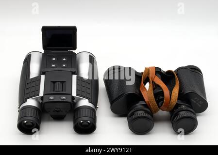Modern binoculars and vintage binoculars isolated on white background. Vintage binoculars Vs modern binoculars. Stock Photo