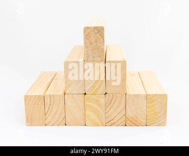 wooden bars lie stacked in pyramid form on white isolated background Stock Photo