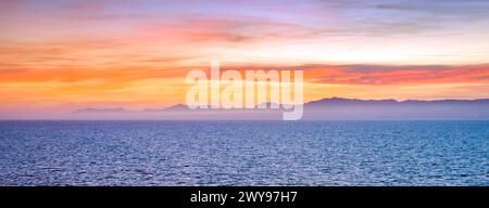Sunset with ling clouds over a sea coast Stock Photo
