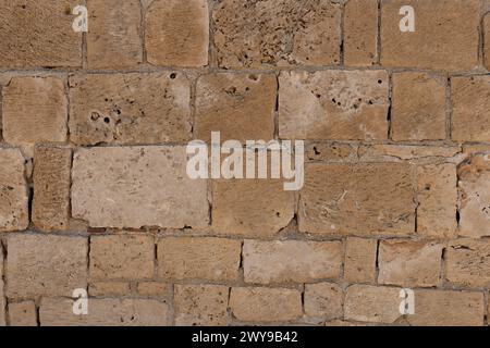 Textured Sandstone Wall. Close-up of weathered sandstone blocks in wall Stock Photo