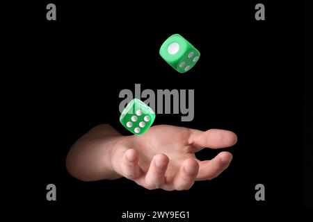 Man throwing green dice on black background, closeup Stock Photo