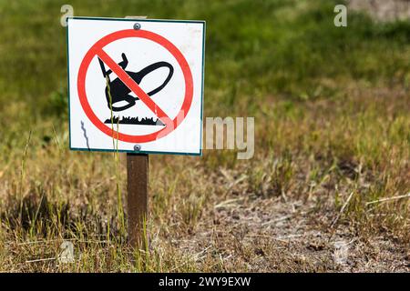 Do not walk on grass, park sign on small wooden pole mounted on the lawn Stock Photo