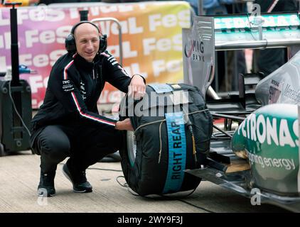 Pit Crewman attending to the tyres on the  Mercedes F1 W04, for the 75th Anniversary Demonstration of Post '66, Grand Prix at Silverstone Stock Photo