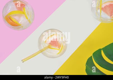 Summertime - drinks, cocktails with fruits on pink and yellow background. Top view. Stock Photo