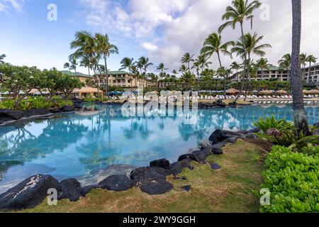 Palm trees reflect in the beautiful turquoise water of one of the luxurious swimming pools at the Grand Hyatt Kauai Resort and Spa in Koloa, Hawaii. Stock Photo
