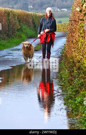 Devon, UK. 5th Apr, 2024. UK Weather: Storm Kathleen warning with lanes already under water at Dunsford Devon. Pictured Raich Keene and Raphael the retriever have a paddle. Credit: nidpor/Alamy Live News Stock Photo
