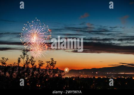 Sunset sky with bursting fireworks over Missoula Valley Stock Photo