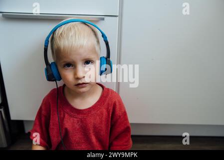 Portrait of toddler wearing headphones looking at camera Stock Photo